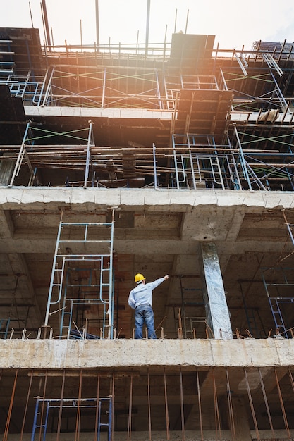 Ingeniero con planos en sitio de construcción de edificios