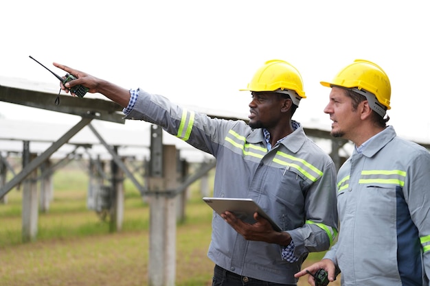 Ingeniero de planta de energía solar examinando solución eléctrica de mantenimiento de técnico de paneles fotovoltaicos