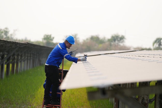 Ingeniero de planta de energía solar examinando solución eléctrica de mantenimiento de técnico de paneles fotovoltaicos