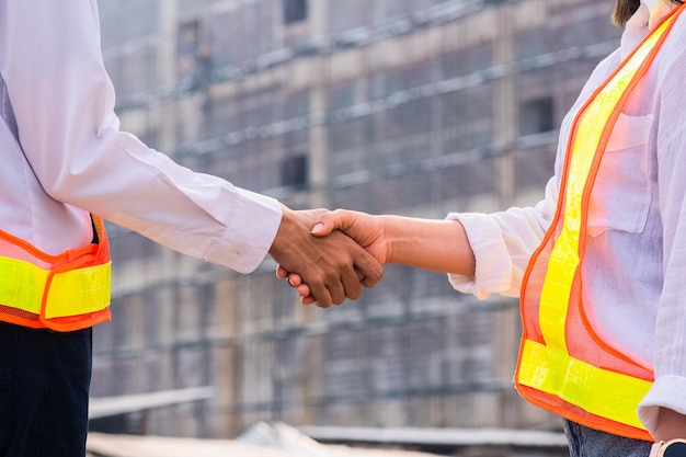 Ingeniero de primer plano del concepto de trabajo en equipo de la mano Agitar el fondo del sitio de construcción del trabajo en equipo de la mano