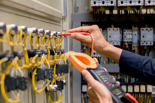 Ingeniero probador de medición de voltaje y corriente en control de gabinete eléctrico