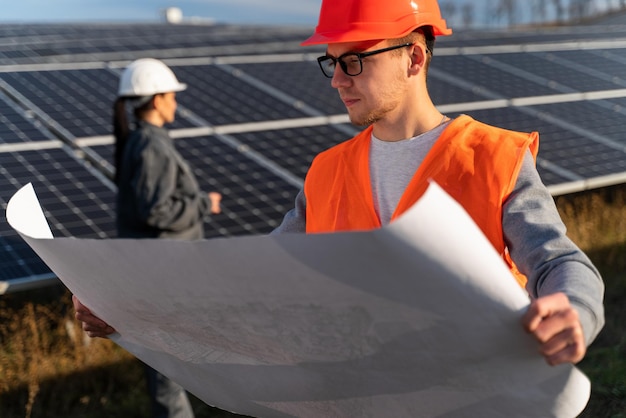 Ingeniero profesional barbudo en uniforme con documento de proyecto innovador del parque energético exterior