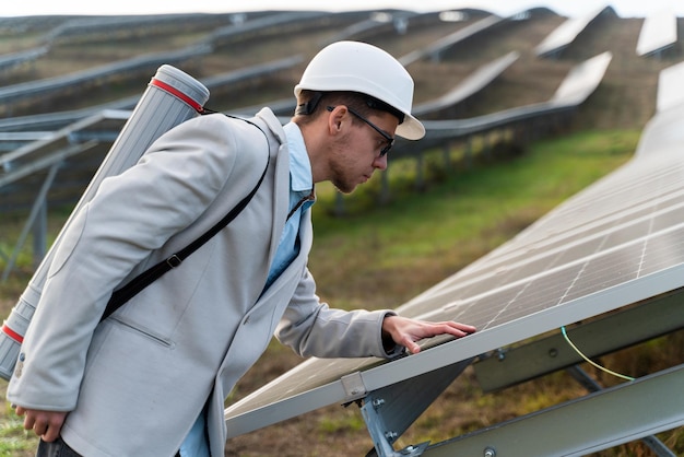 Ingeniero profesional en casco comprobando los paneles solares.