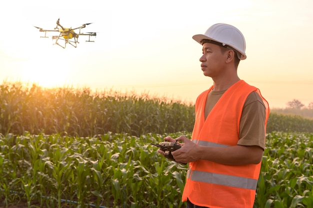 Un ingeniero que controla drones rociando fertilizantes y pesticidas sobre tierras de cultivo