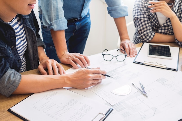 Ingeniero que discute la reunión que trabaja en el proyecto del modelo arquitectónico en el emplazamiento de la obra.