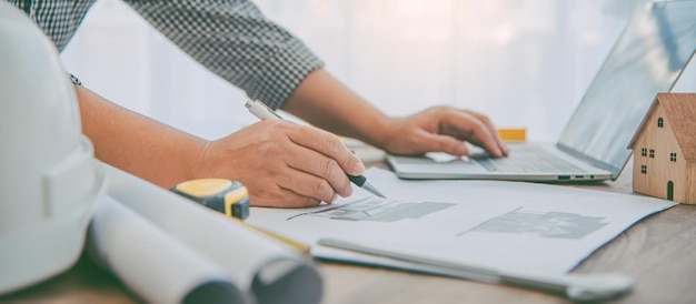 Ingeniero que trabaja en la oficina con planos, inspección en el lugar de trabajo para plan arquitectónico, proyecto de construcción, construcción empresarial