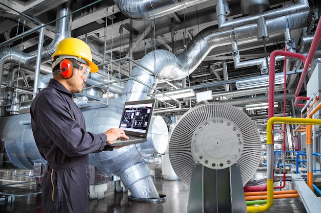 Foto ingeniero que usa computadora portátil para el mantenimiento en la industria de la planta de energía térmica