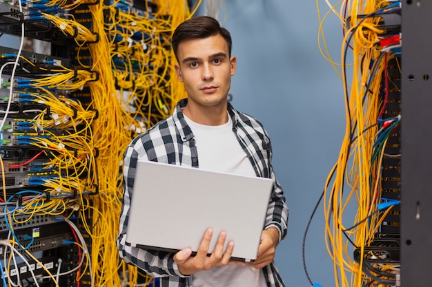 Foto ingeniero de redes en sala de servidores, plano medio