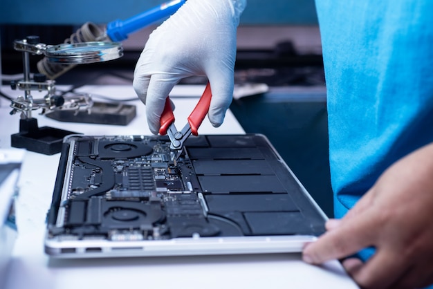 ingeniero repara la computadora portátil y la placa base.