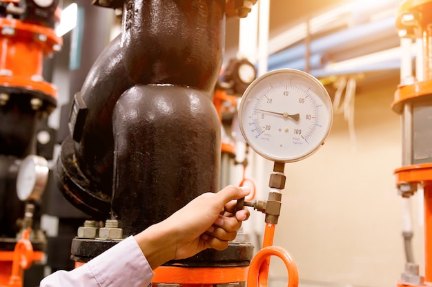 Ingeniero revisando la bomba de agua del condensador y el manómetro