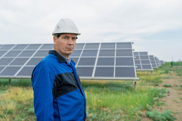 Foto ingeniero de servicio hombre de pie frente a los paneles solares técnico de mantenimiento de células solares en e solar