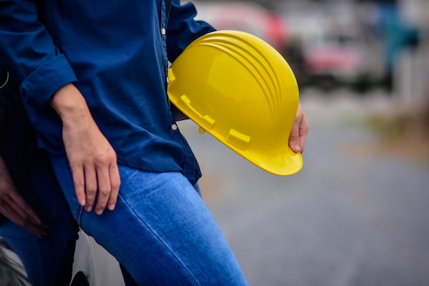 Ingeniero de sexo femenino que sostiene la seguridad del casco Lugar de trabajo al aire libre de pie