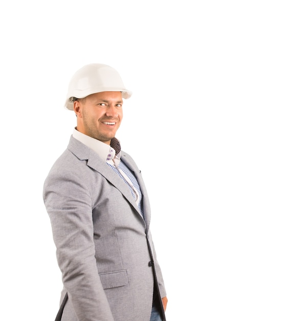 Ingeniero de sexo masculino de mediana edad sonriente en abrigo gris y casco blanco. Aislado sobre fondo blanco.