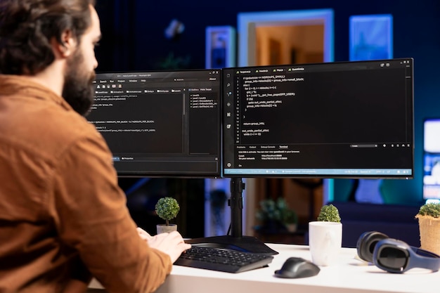 Ingeniero de sistemas en la sala de estar escribiendo líneas de código en la computadora