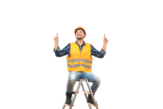 El ingeniero de la sonrisa sentado en la escalera sobre el fondo blanco.