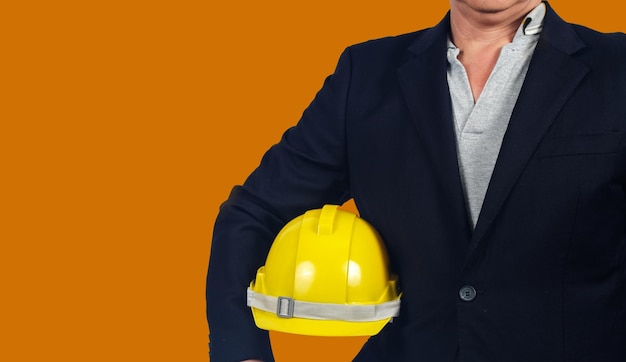 Ingeniero sosteniendo el casco amarillo para la seguridad de los trabajadores