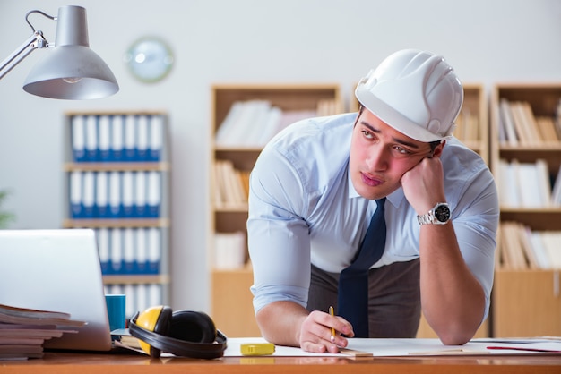 Ingeniero supervisor trabajando en dibujos en la oficina