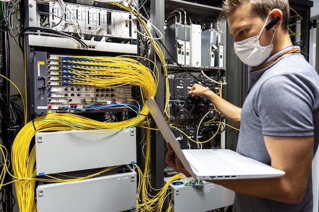 Ingeniero técnico solucionando problemas con servidores y datos en la sala de cables