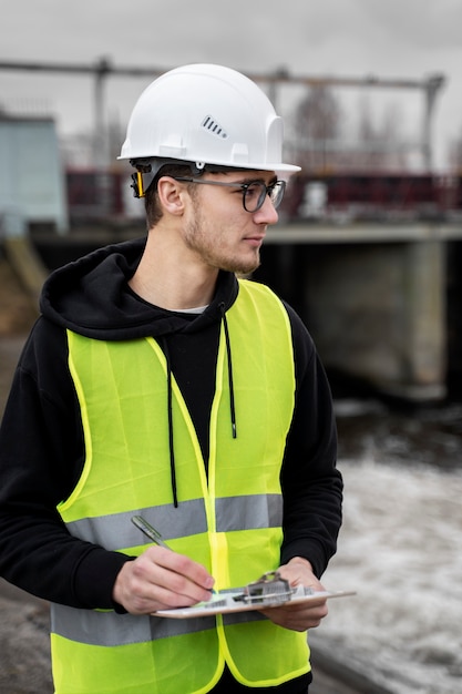 Foto ingeniero de tiro medio con casco de seguridad.