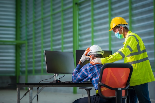 Ingeniero y trabajador de la construcción con máscaras faciales en el trabajo