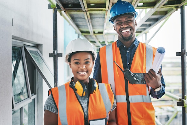 Ingenieros afroamericanos felices y orgullosos en un sitio de construcción planeando un edificio juntos Retrato de jóvenes contratistas parados en un apartamento que será renovado para un proyecto juntos