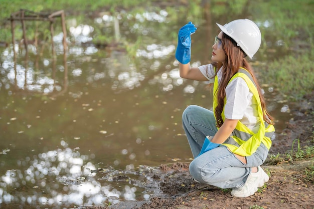 Foto los ingenieros ambientales inspeccionan la calidad del agua. llevan el agua al laboratorio para su análisis. comprueban el contenido de minerales en el agua y el suelo. comprueban si hay contaminantes en las fuentes de agua.