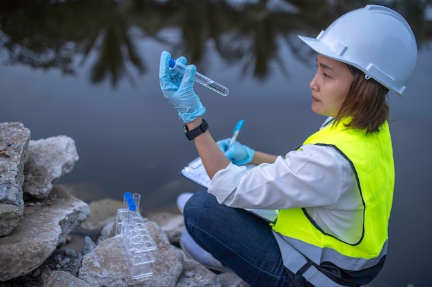 Los ingenieros ambientales inspeccionan la calidad del agua Traen el agua al laboratorio para su ensayo Comprueben el contenido mineral en el agua y el suelo Comprueben los contaminantes en las fuentes de agua