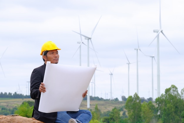 Los ingenieros analizan los planos de proyectos de turbinas eólicas de energía limpia para generar electricidad.