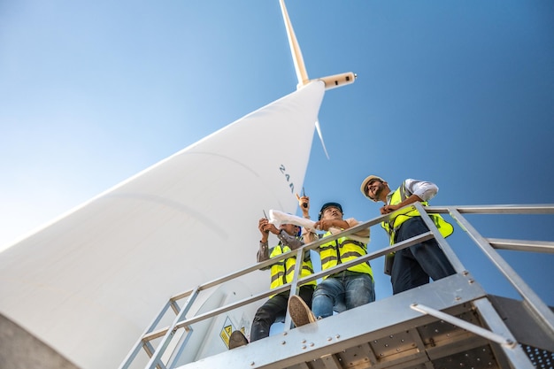 Ingenieros asiáticos trabajando en campo al aire libre. Los trabajadores revisan e inspeccionan la construcción y el aro de la máquina.