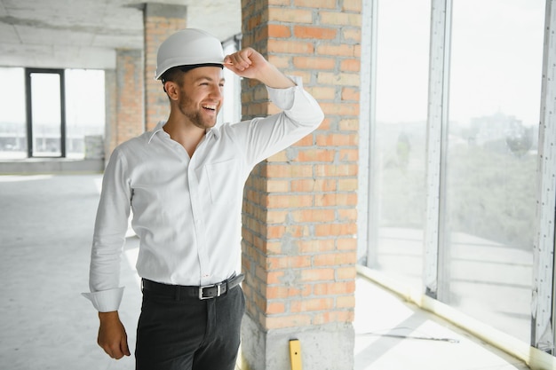 Ingenieros de cerca que trabajan en un sitio de construcción con planos. Concepto de ingeniería y arquitectura