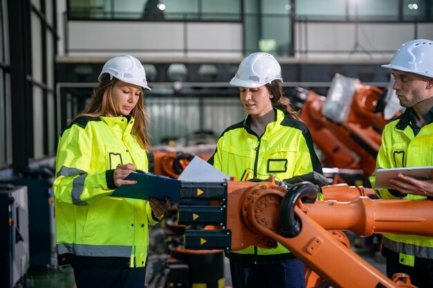 Los ingenieros colaboran en operaciones de ensamblaje robótico en una instalación de alta tecnología