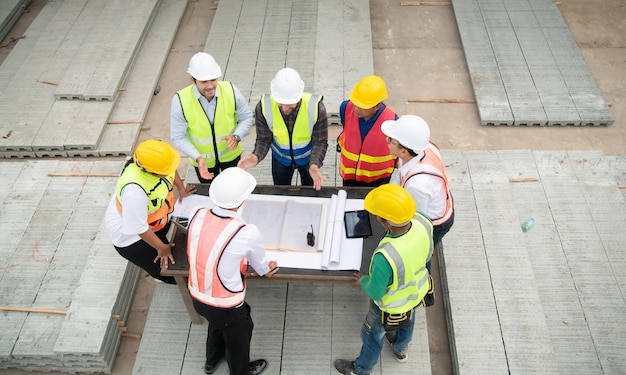 Foto ingenieros de construcción, arquitectos y capataces forman un grupo participan en una reunión para planificar nuevos proyectos de construcción