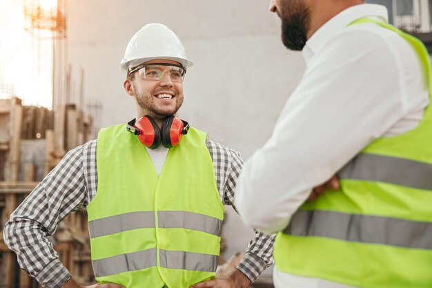 Ingenieros de la construcción que se comunican cerca del edificio