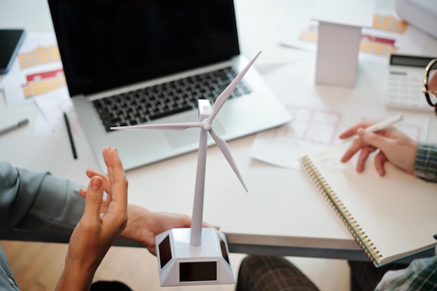 Ingenieros de energía sostenible discutiendo turbina eólica