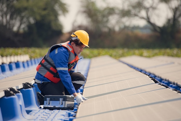 Foto los ingenieros fotovoltaicos trabajan en fotovoltaicos flotantes inspeccionan y reparan el equipo de paneles solares