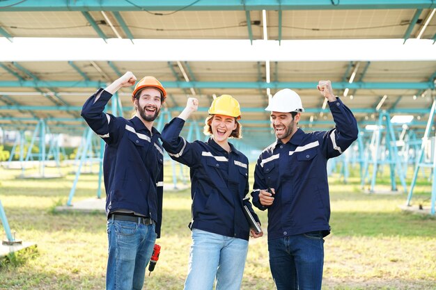 Ingenieros instalando paneles solares en el techo Ingenieros masculinos caminando a lo largo de filas de paneles fotovoltaicos