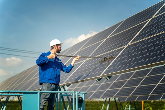 Ingenieros instalando paneles solares en el techo Ingenieros masculinos caminando a lo largo de filas de paneles fotovoltaicos