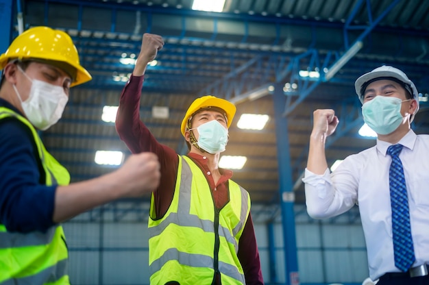 Los ingenieros llevan una mascarilla feliz en una fábrica moderna