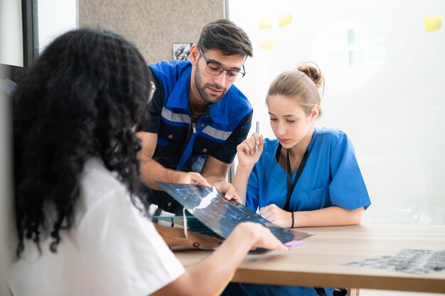 Foto ingenieros, médicos y fisioterapeutas trabajan juntos para diseñar un robot con un brazo y una mano