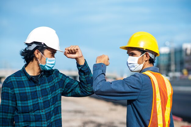 Ingenieros que se saludan tocándose los codos