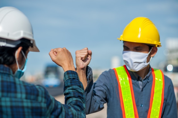 Foto ingenieros que se saludan tocándose los codos