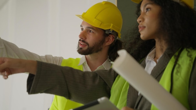 Ingenieros que usan tabletas para hablar y hacer una lluvia de ideas juntos en el sitio de construcción