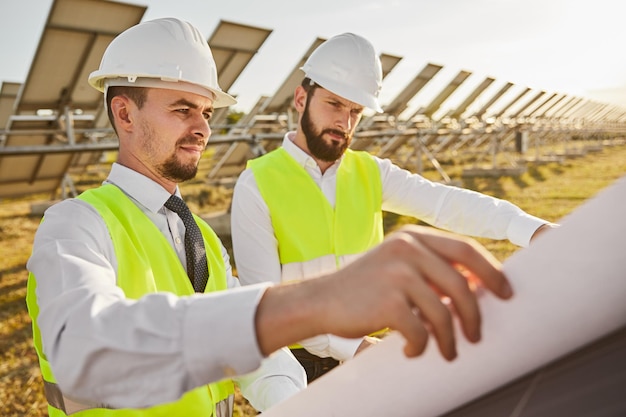 Ingenieros revisando planos en la estación de energía solar