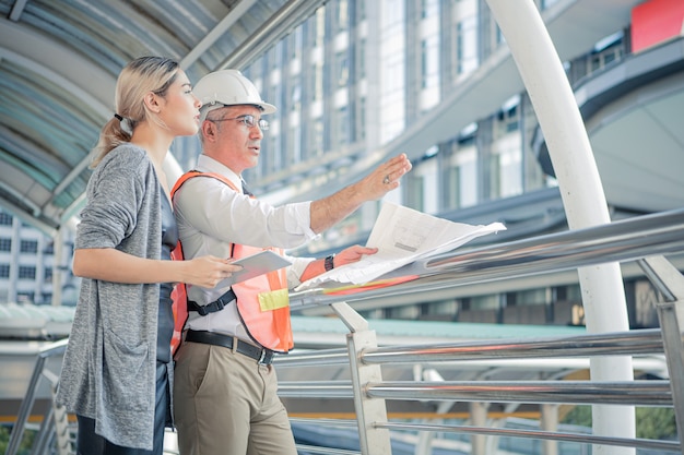 Los ingenieros superiores describen los detalles del proyecto a una clienta joven en el lugar de trabajo