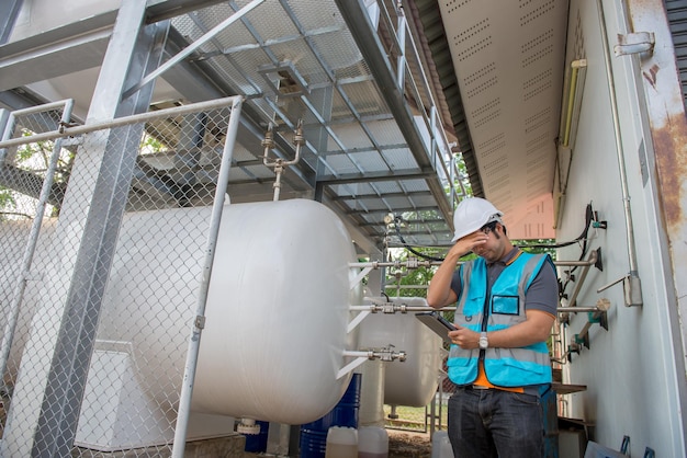 Los ingenieros trabajan en el lugar para mantener el control del programa de mantenimiento preventivo de helio líquido. La gente de Tailandia está estresada por el trabajo.