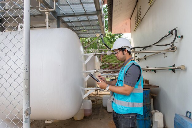 Los ingenieros trabajan en el lugar para mantener el programa de mantenimiento preventivo de helio líquido comprobando la gente de Tailandia