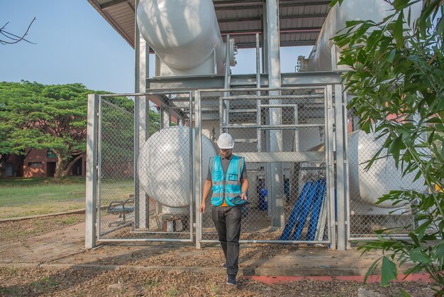 Los ingenieros trabajan en el lugar para mantener el programa de mantenimiento preventivo de helio líquido comprobando la gente de Tailandia