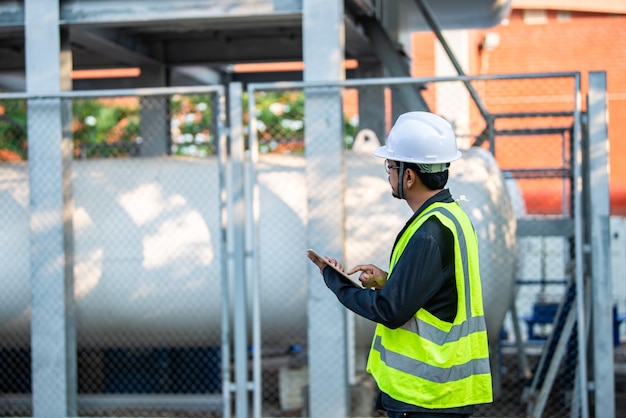 Los ingenieros trabajan en el lugar para mantener el programa de mantenimiento preventivo de helio líquido comprobando la gente de Tailandia