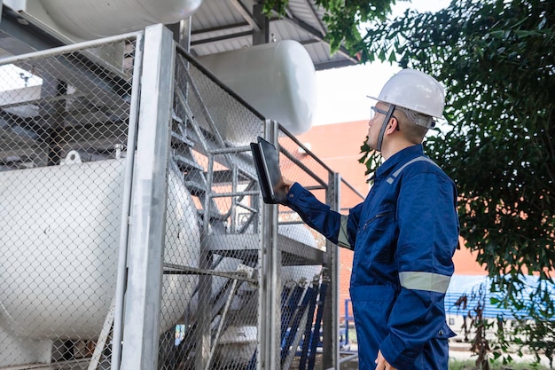 Los ingenieros trabajan en el lugar para mantener el programa de mantenimiento preventivo de helio líquido comprobando la gente de Tailandia