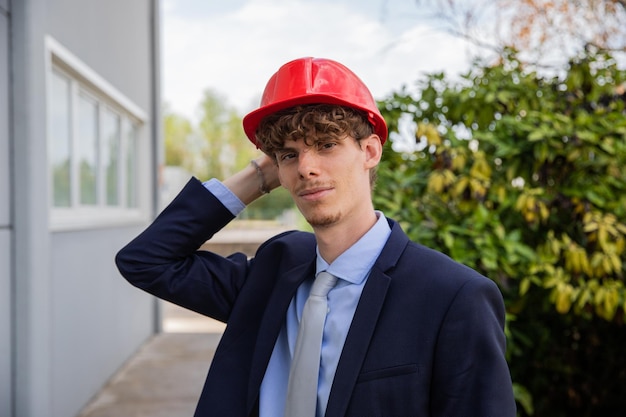 Ingenieur auf der Baustelle trägt einen Schutzhelm auf dem Kopf, elegant gekleidete Person bei der Arbeit